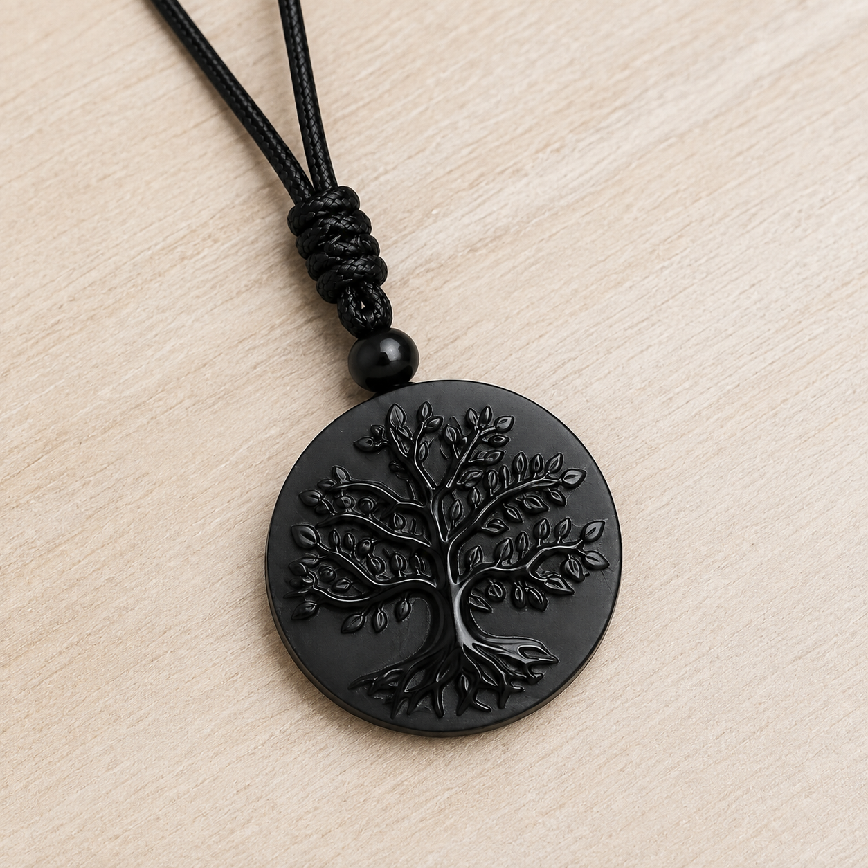 Pendentif Arbre de Vie noir en obsidienne naturelle sur fond naturel